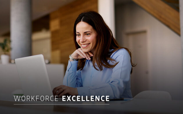 A woman in a blue shirt sits at a desk, smiling at her laptop. The text "Workforce Excellence" is displayed at the bottom of the image.